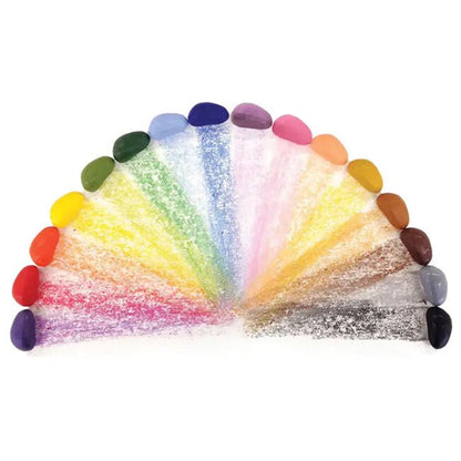 A set of multicolor rock-shaped crayons arranged in a semi-circle fan shape on a plain white background, showing a wide range of colors from red and orange through yellow, green, blue, purple, pink, brown, gray, and black.