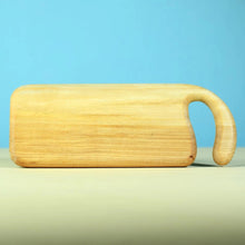 Wooden cutting board with handle on a light blue background