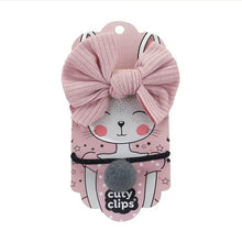 Cuty Clips pink, black, and grey hair bands with branded packaging on a white background