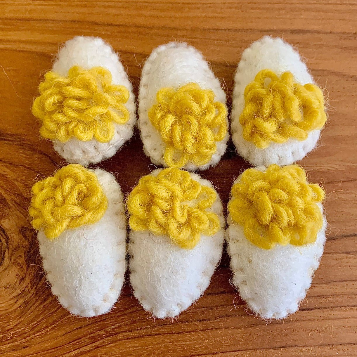 6 felted deviled eggs on a wood surface