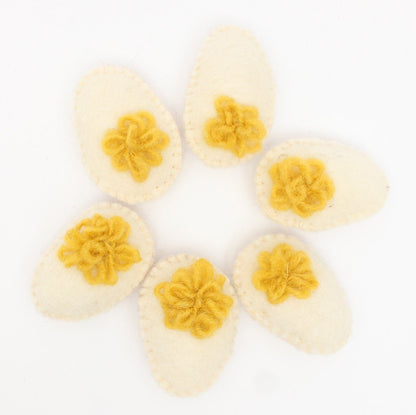 6 felted deviled eggs arranged in a circle on a white background