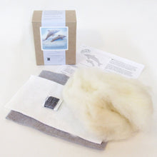 Contents of dolphin family sewing kit on a light background