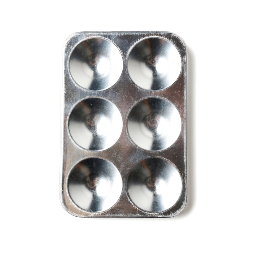 Metal paint palette with six circular compartments on a white background