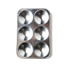 Metal paint palette with six circular compartments on a white background