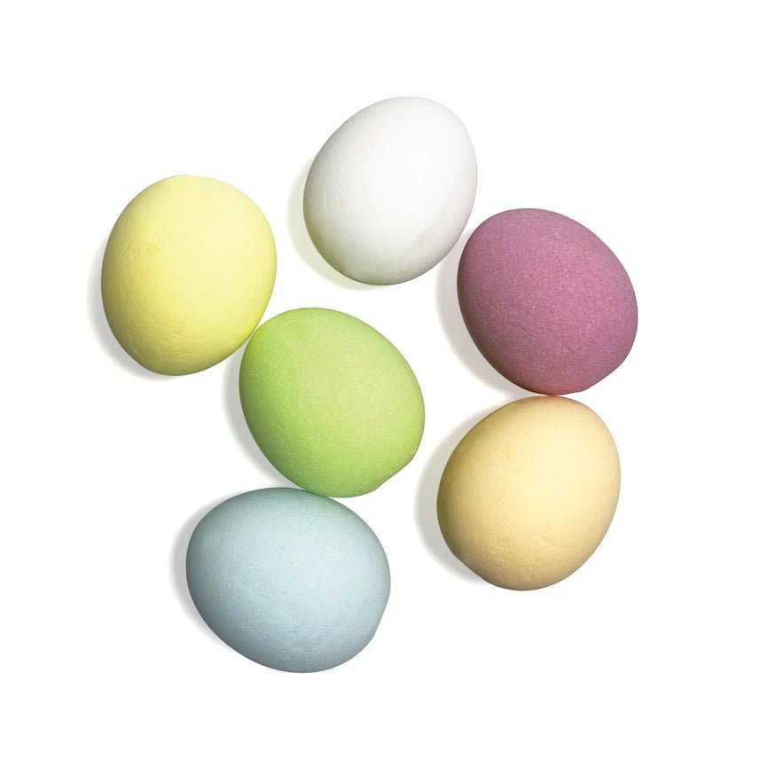 Set of six pastel-colored bath bomb eggs on a white background