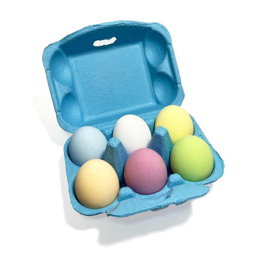 Blue egg carton with colorful bath bomb eggs on a white background
