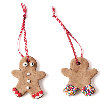 Two gingerbread man ornaments with candy cane strings on a white background