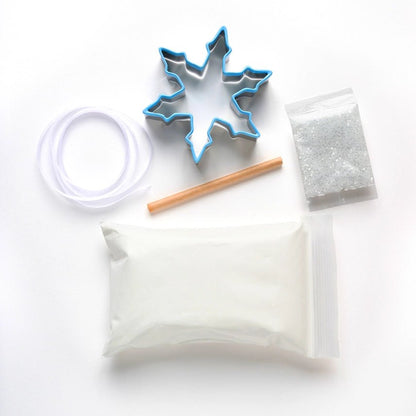 Cookie cutter, wooden stick, and small container on a white background