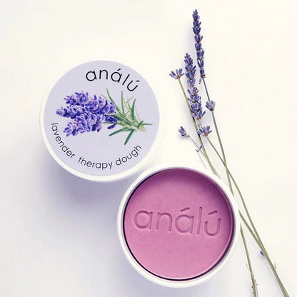 Lavender Therapy dough surrounded by a sprig of lavender on a white background