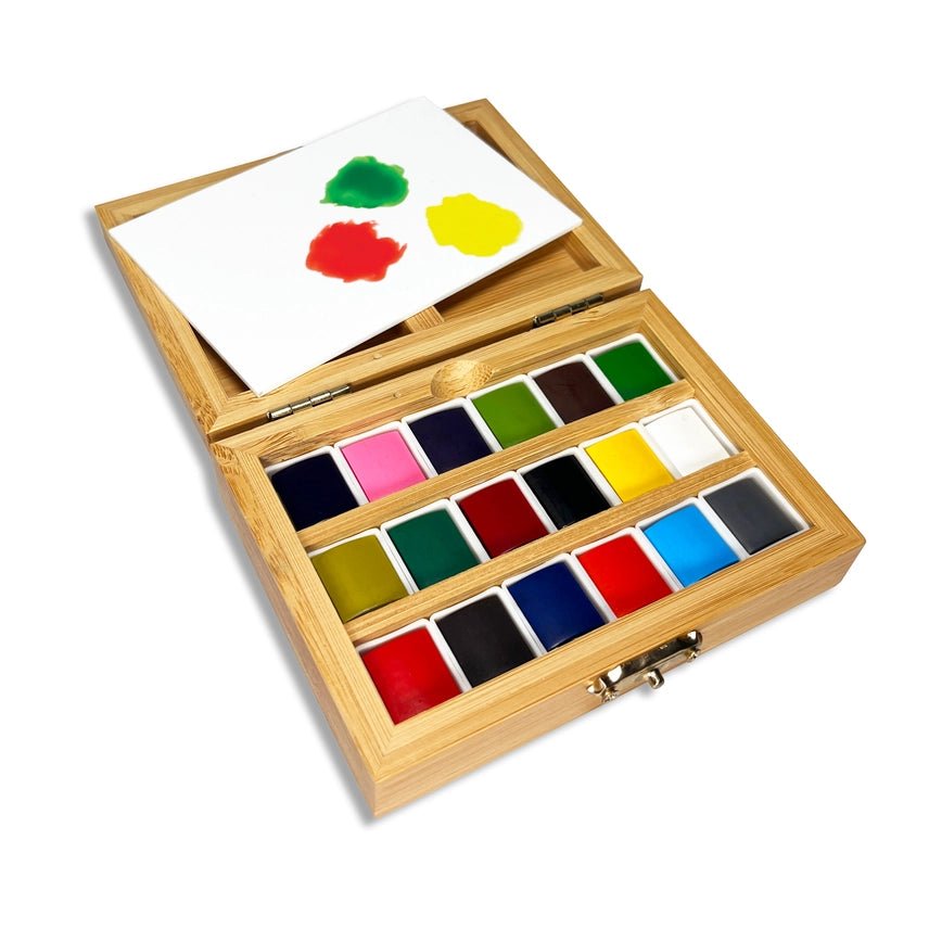 Watercolor set with 18 different colors and a white palette, in a bamboo box on a white background