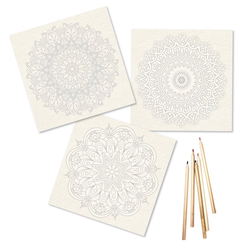 Three white cards with black mandala designs and wooden pencils on a white background