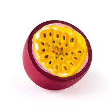 Purple wooden passionfruit half with yellow inside and brown seeds on a white background