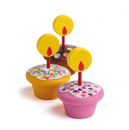 1 vanilla, 1 chocolate, and 1 pink muffin with candles and wooden flames on a white background