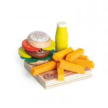Wooden veggie burger, sauce bottle, and sweet potato fries on a serving board against a white background