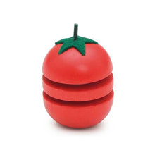 Red wooden tomato with a green stem on a white background