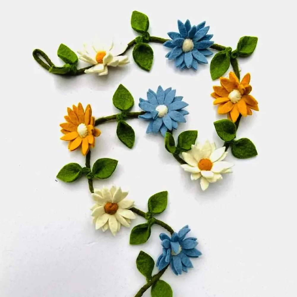 Decorative felt flower garland with blue, orange, and white flowers on a white background