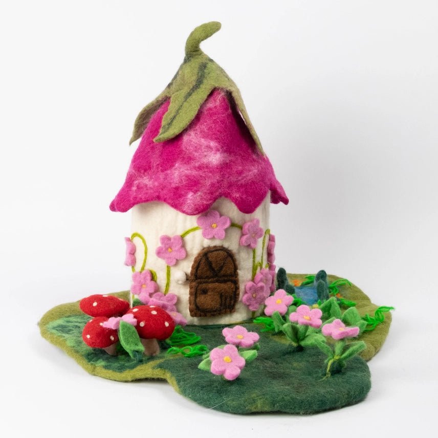 Felt fairy house with pink roof and flowers on a white background