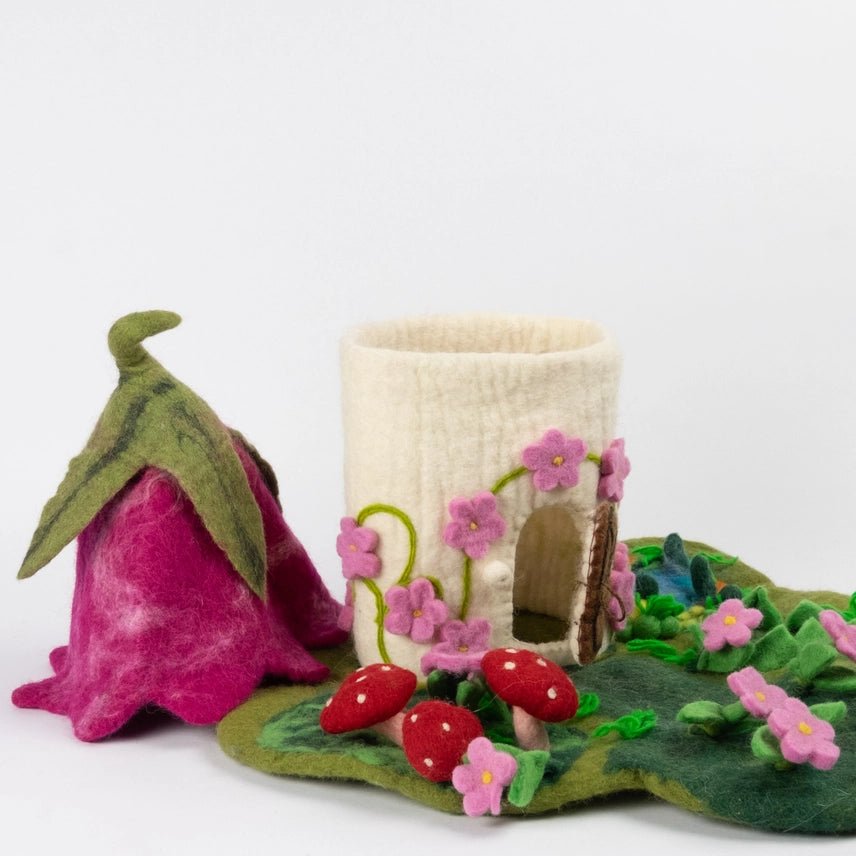 Handmade felt playset featuring pink fairy cottage with removable roof on a white background