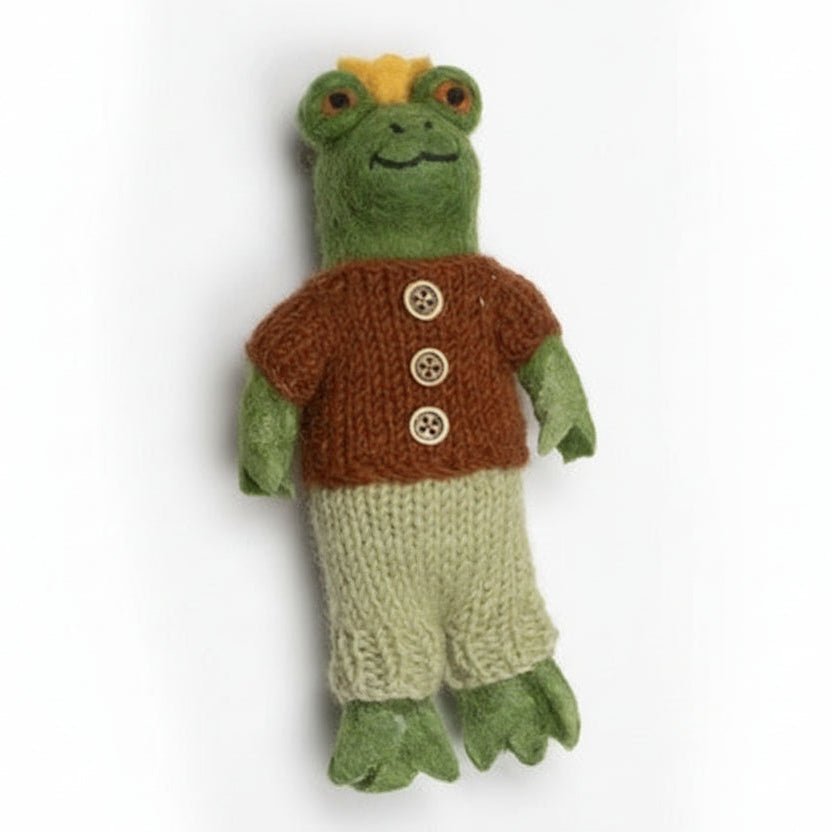 Knitted frog toy with a brown vest and green pants on a white background
