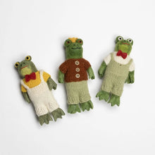 Three felted frog toys dressed in different outfits on a white background