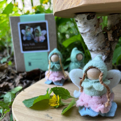 Small fairy figurines on a wooden surface with a natural background