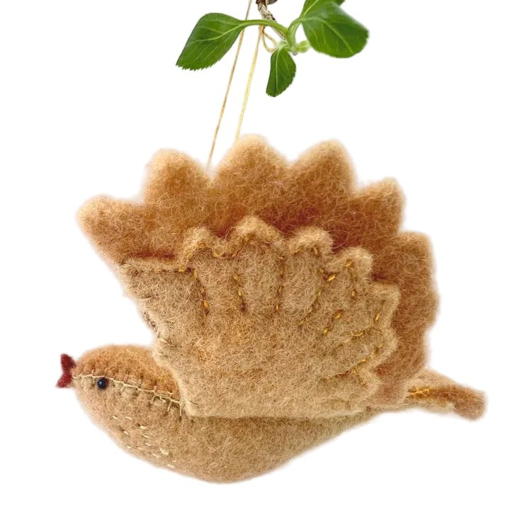 Yellow felt bird ornament hanging from a branch on a light background