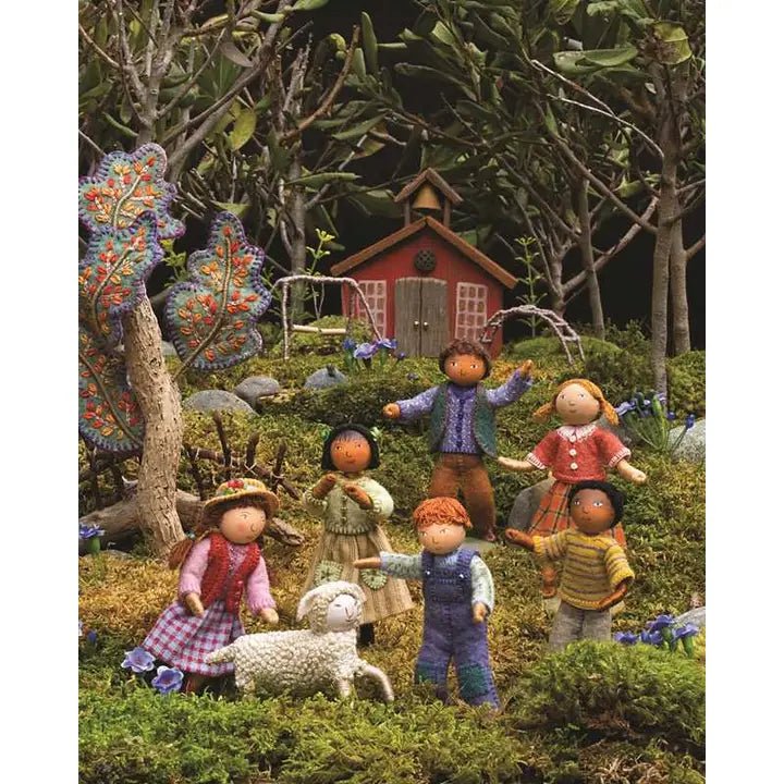 Miniature scene with children and a red cabin in a forest setting