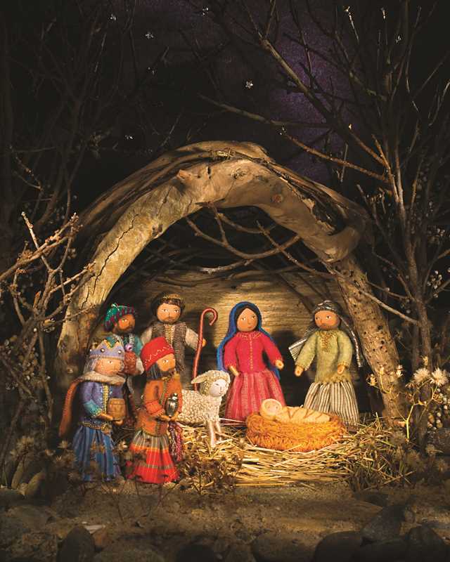 Nativity scene with figures in a dark, forested setting