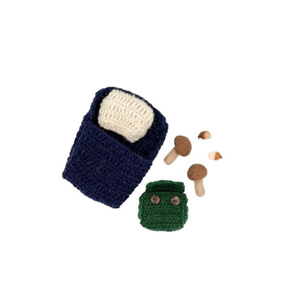 Crocheted items including a blue bag, green container with buttons, and felted mushrooms on a white background