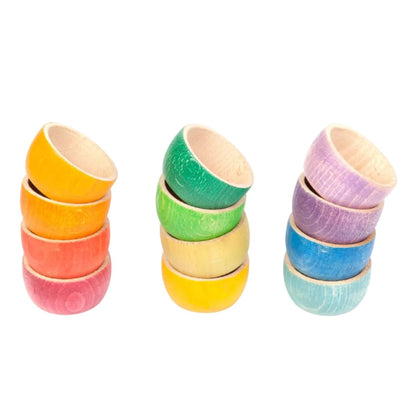 12 colorful wooden bowls arranged in rainbow order on a white background