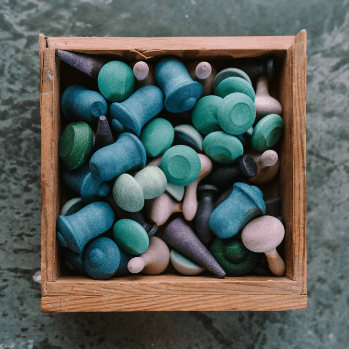 Wooden box filled with colorful wooden shapes on a textured surface