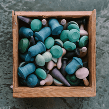 Wooden box filled with colorful wooden shapes on a textured surface