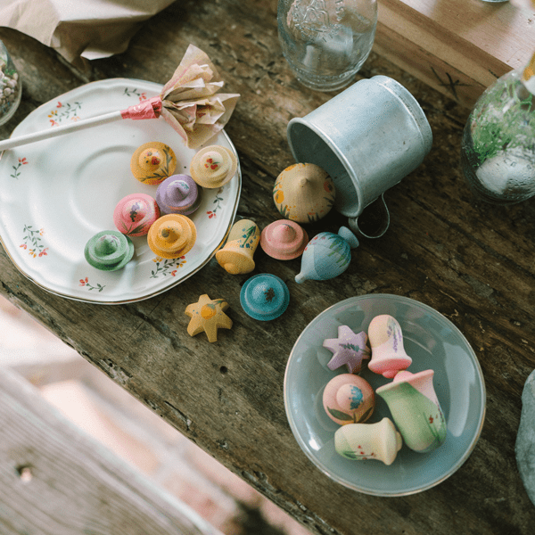 Wooden flowers on small plates with a rustic wooden table setting.