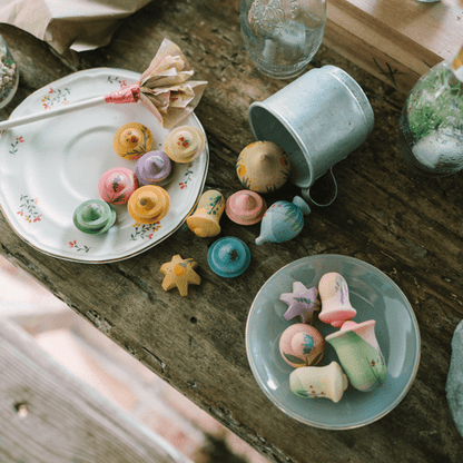 Wooden flowers on small plates with a rustic wooden table setting.