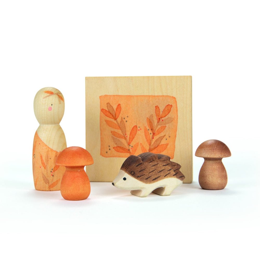 A wooden autumn-themed peg person, two wooden mushrooms, a flower press, and a wooden hedgehog figure on a white background