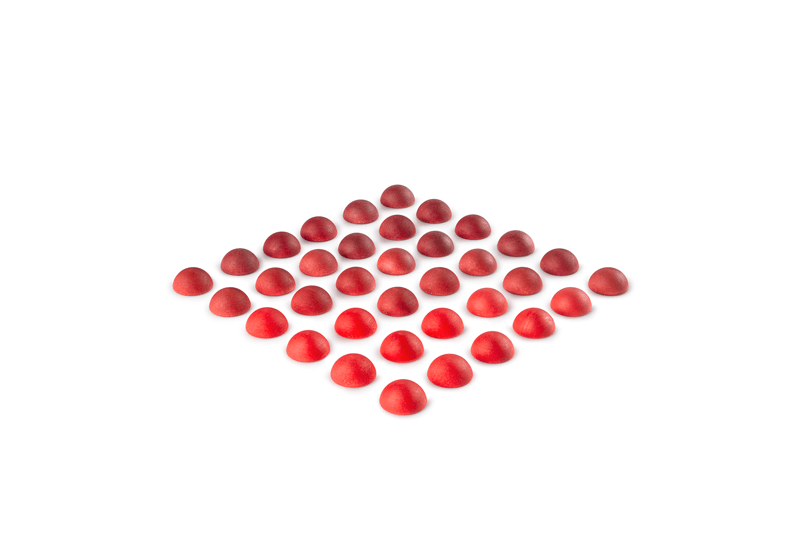 Wooden half spheres in various shades of red on a white background