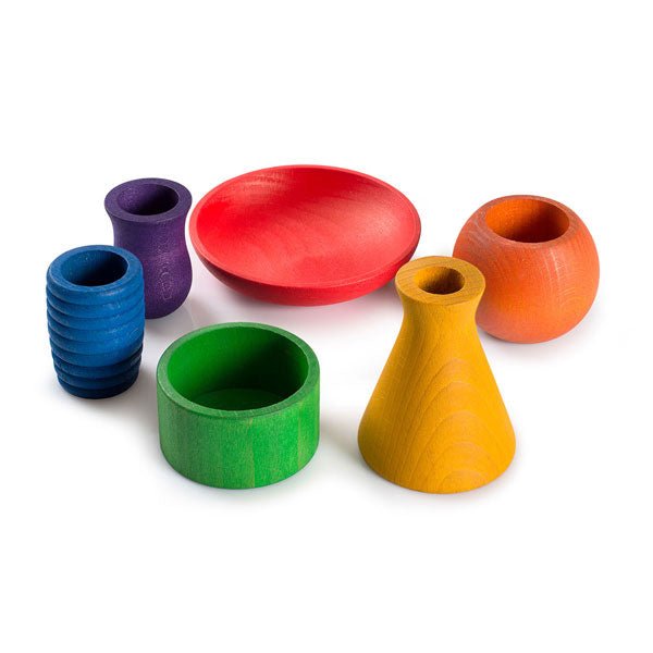 Set of colorful wooden pots of varying colors and shapes on a white background