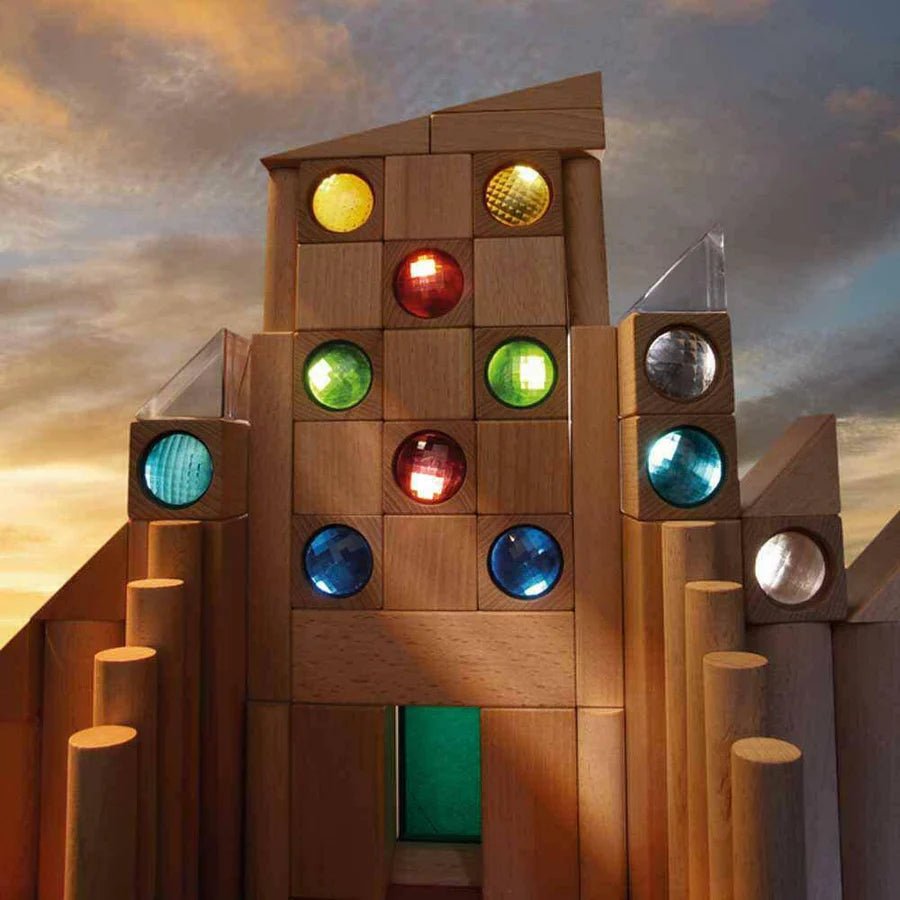 Wooden block structure with colorful kaleidoscope blocks against a sunset sky