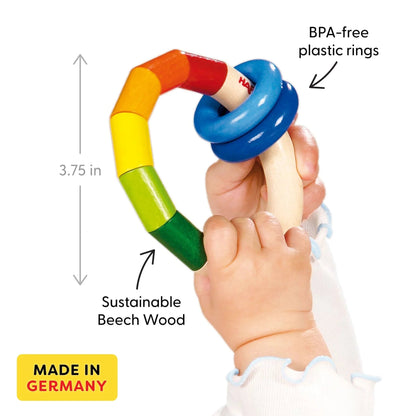 Colorful baby teething ring held by a child's hand with text indicating BPA-free plastic rings, sustainable beech wood, and 'Made in Germany'.