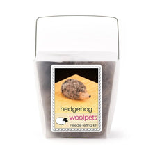 Frosted plastic container with materials to make a felted hedgehog with woolpets branding on a white background