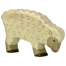 Wooden sheep figure with a textured pattern on a white background
