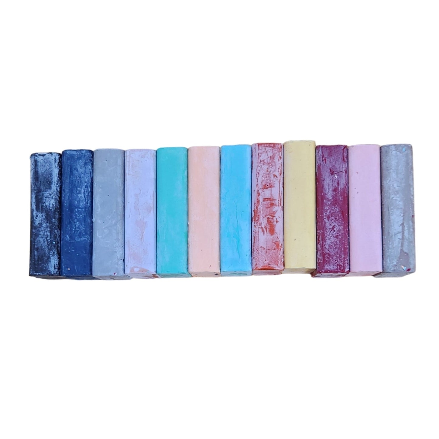 Set of colorful beeswax crayon blocks on a white background