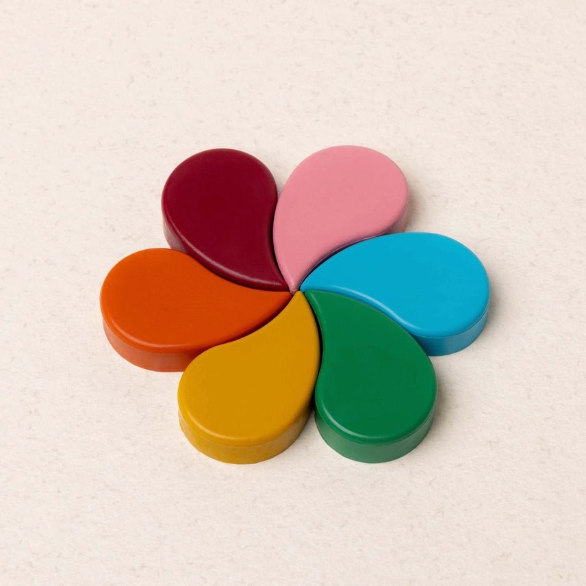 Colorful petal shaped crayons arranged to look like a flower on a light background