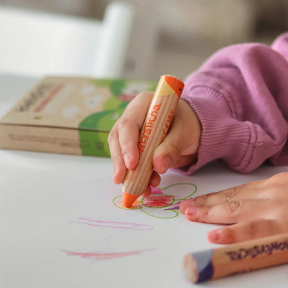 Child's hand holding a Honeysticks pencil coloring on a piece of paper