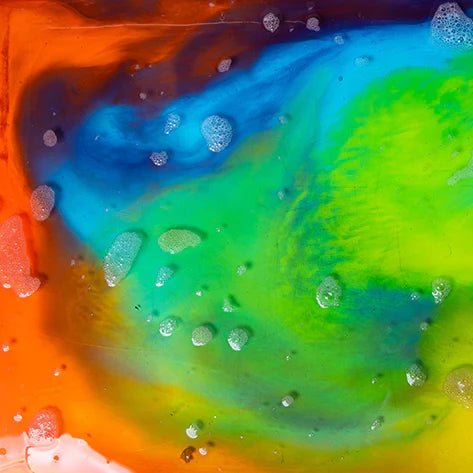 Colorful liquid mixture with bubbles on a multicolored background