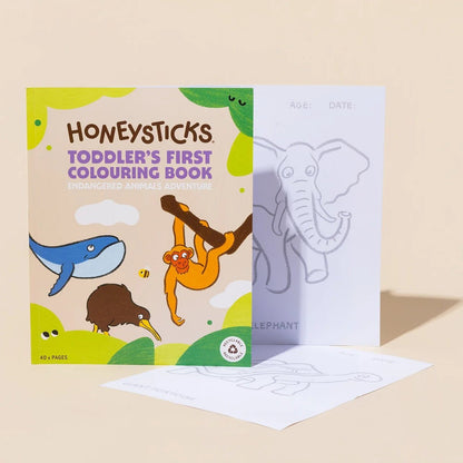 Toddler's first colouring book by Honeysticks, featuring a colorful cover with cartoon animals and two white coloring pages in front, set against a warm beige background.
