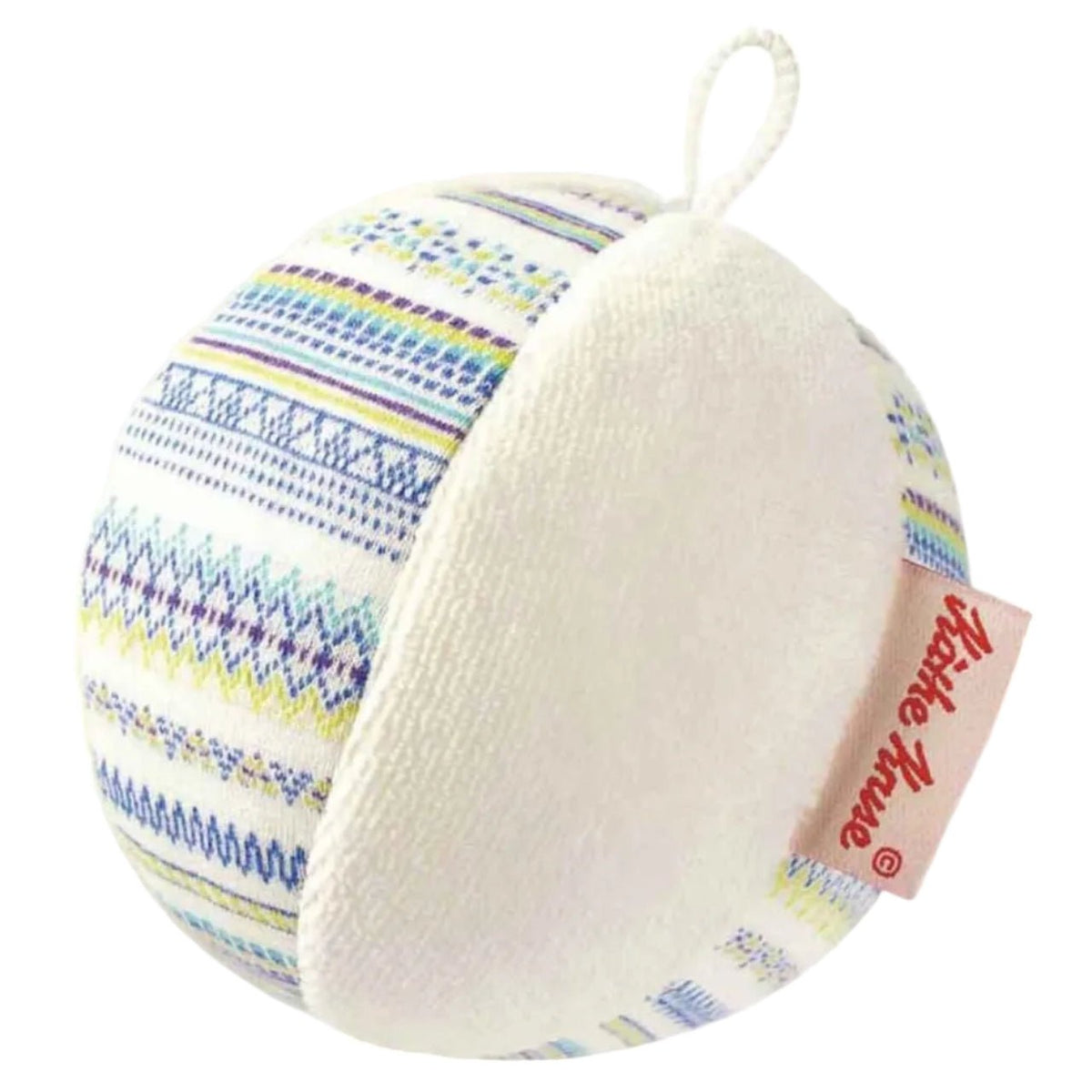 A round, plush rattle ball with a white textured front and a striped patterned side featuring blue, yellow, and purple stripes on a white background. A fabric tag with red text reading 'Kathe Kruse' is attached to the side, and a white hanging loop is at the top.