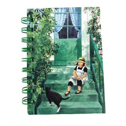 Notebook with a design of a child and black cat on green steps, surrounded by plants.