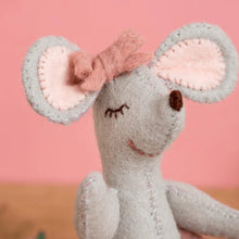 Stuffed mouse toy with pink ears on a pink background