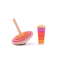 Wooden toy top with colorful rings on a white background